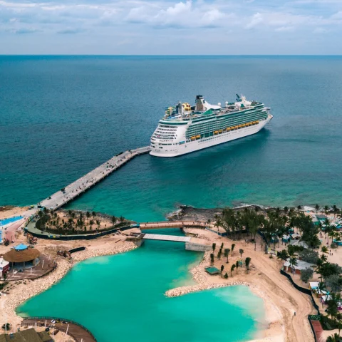 cruise ship in water next to land during daytime