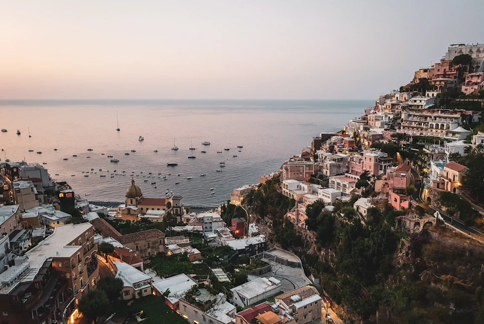 aerial view of a hillside village overlooking a bay at dusk