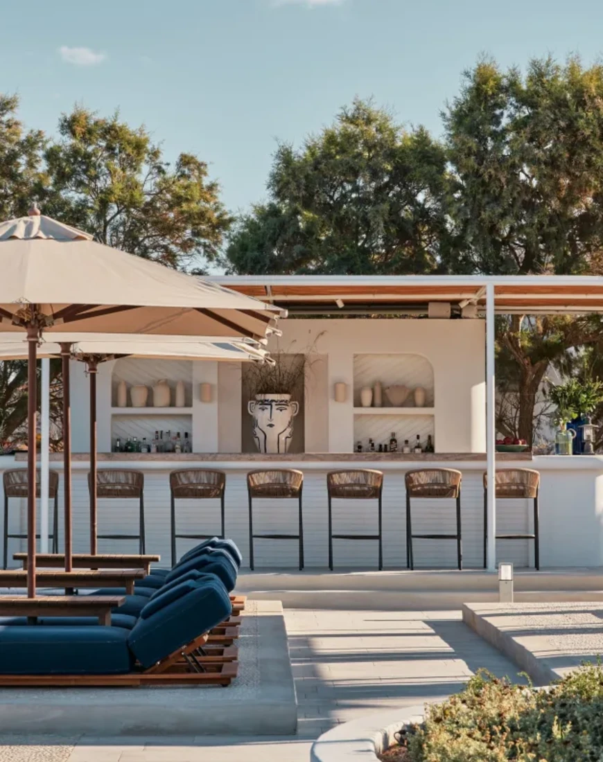 outdoor beach club with navy blue loungers and a white bar