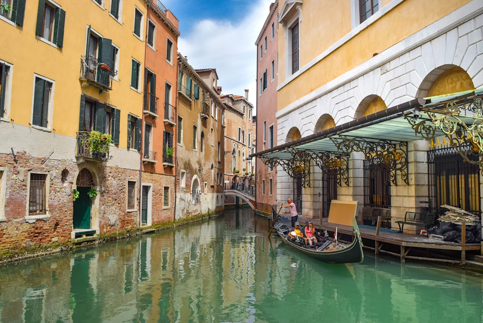 Boat on a river between buildings.