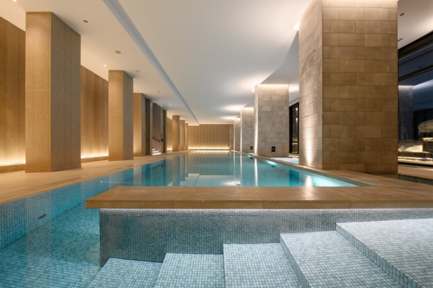 an indoor pool flanked by tan stone pillars