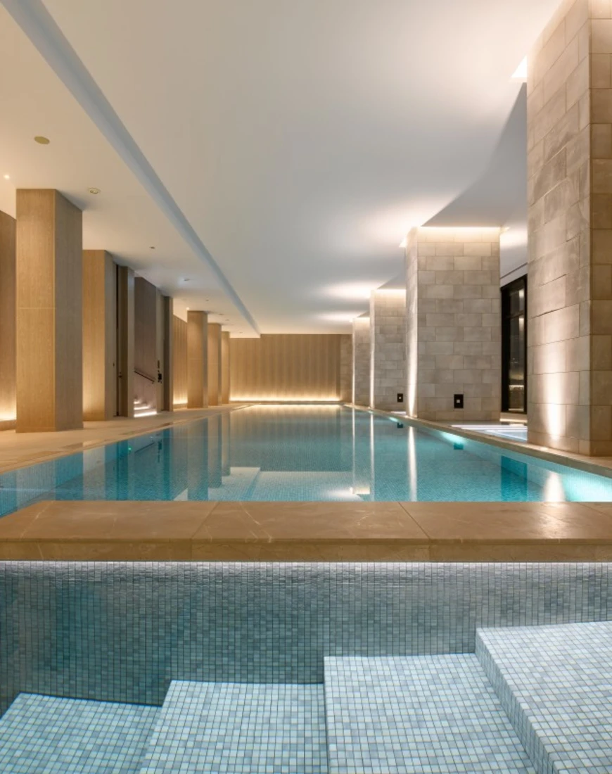 an indoor pool flanked by tan stone pillars