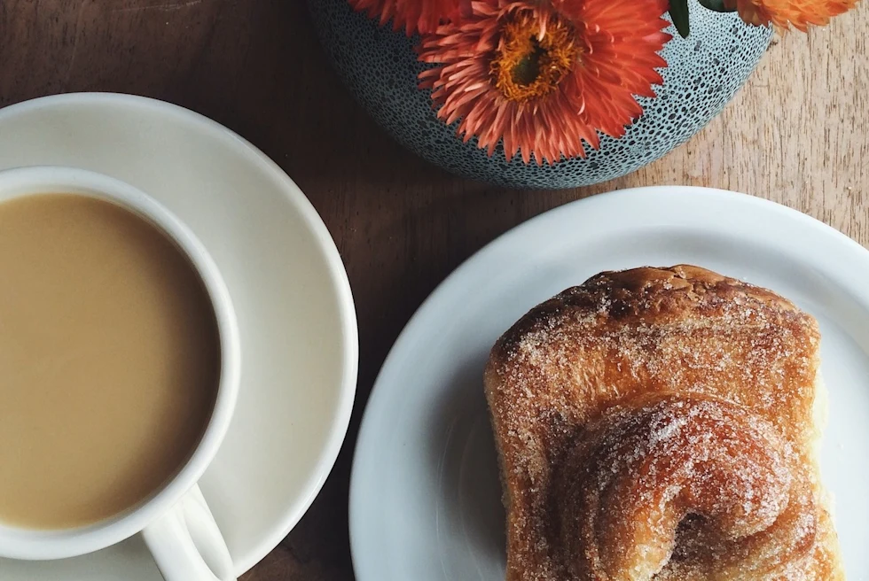 aerial view of a sugar-topped pastry and a cup of coffee