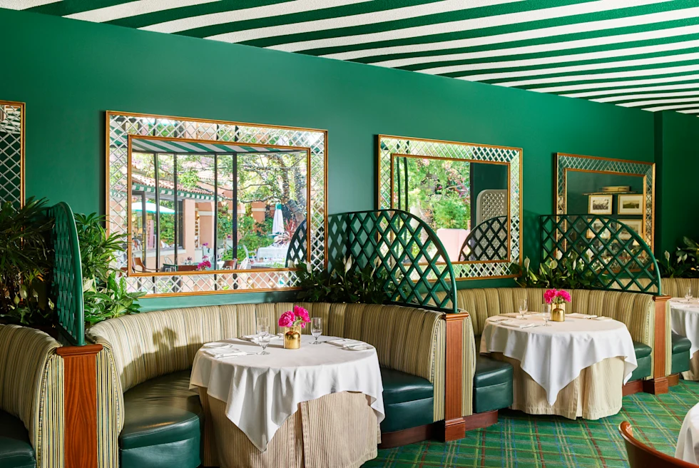 tables with booths in a room with green walls