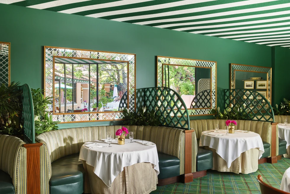 tables with booths in a room with green walls 