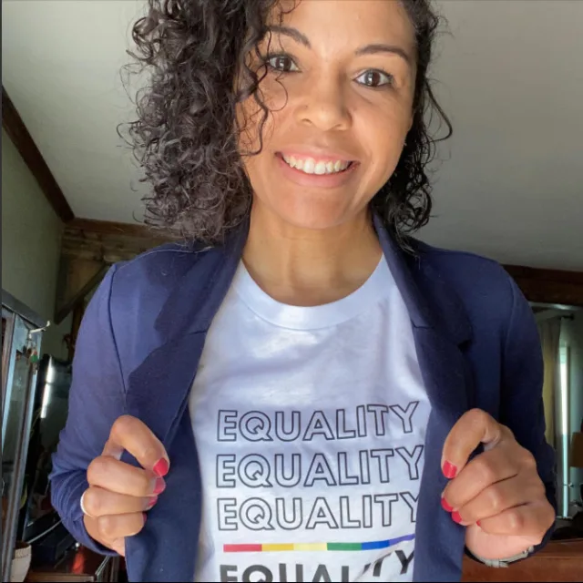 Picture of August in a blue blazer wearing a t-shirt underneath with a graphic that reads 'Equality Equality Equality Equality'