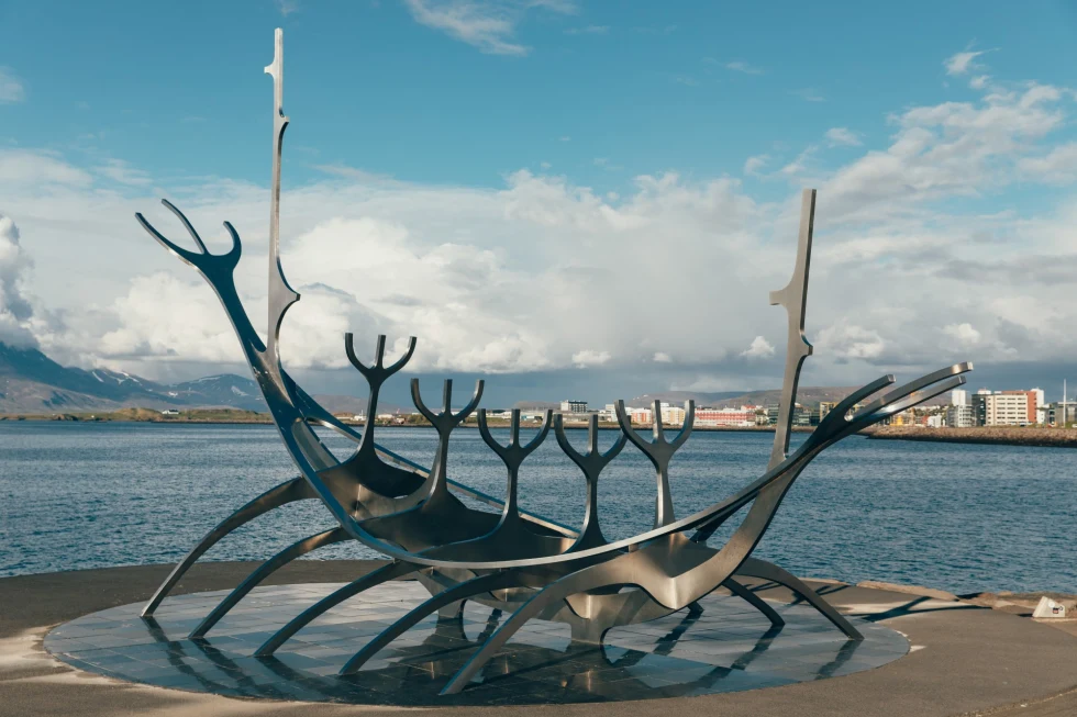 a metal sculpture in front of the sea