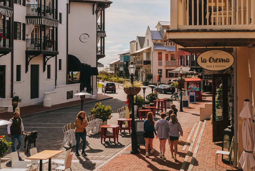 people walking on sidewalk next to shops during daytime