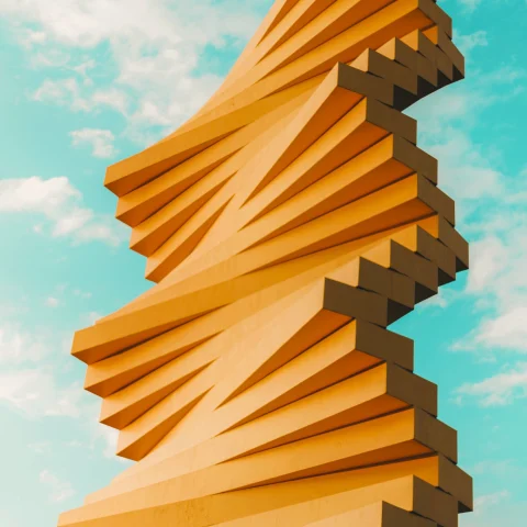 orange abstract sculpture against a blue sky