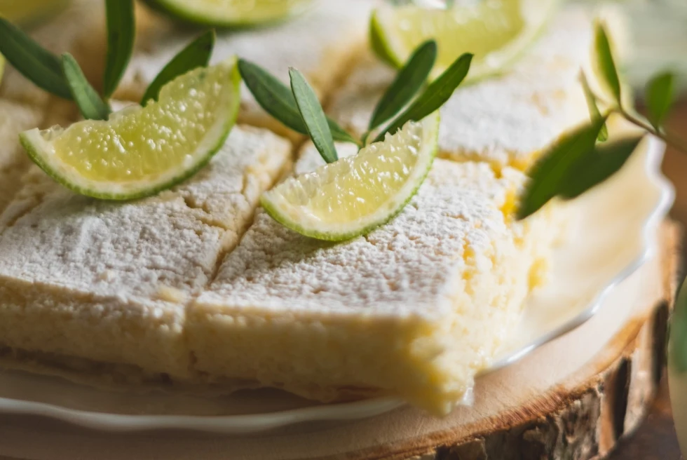 close-up image of key-lime pie squares garnished with lime wedges