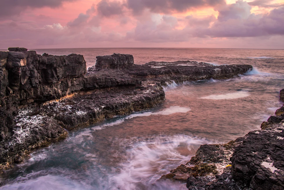 rocky coastline with pink skies