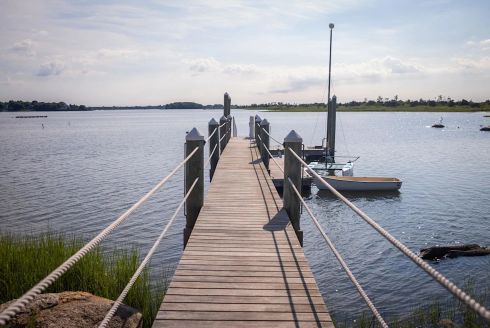 Dock leading to ocean on sunny day in Rhode Island.