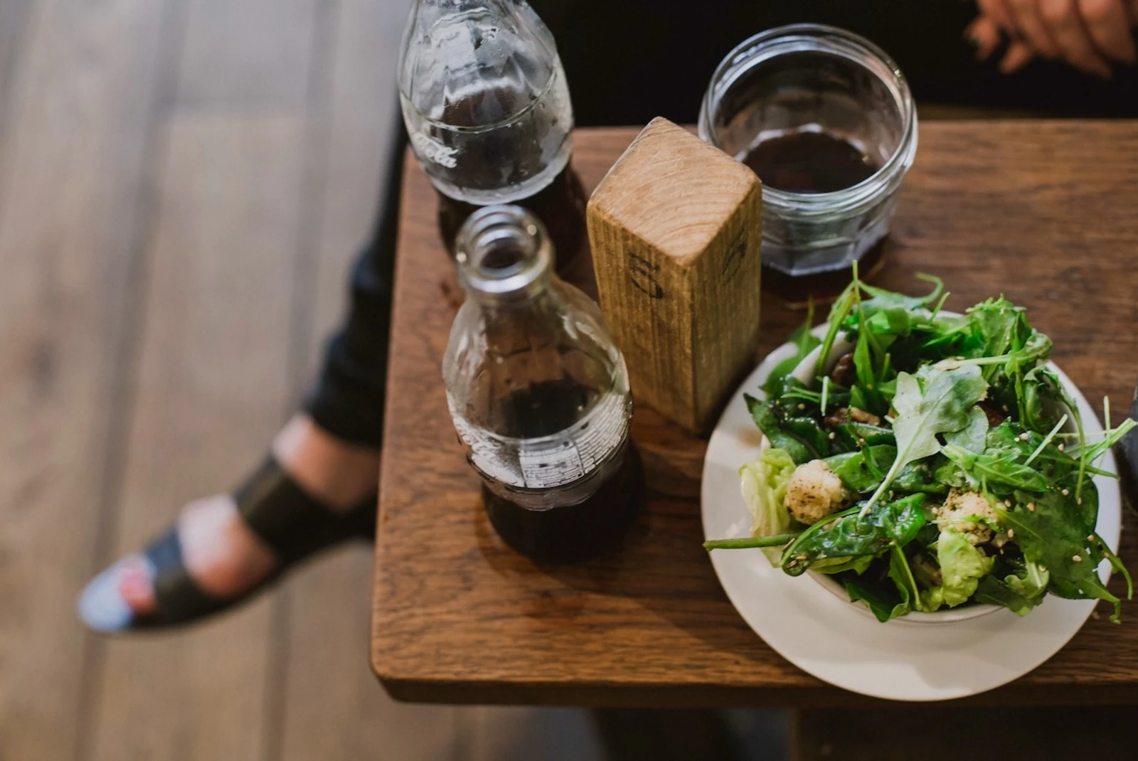 Aerial view of a green salad on a wooden table.