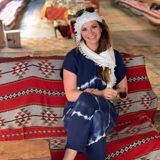 Travel advisor sitting on a colorful rug wearing a traditional turban on head