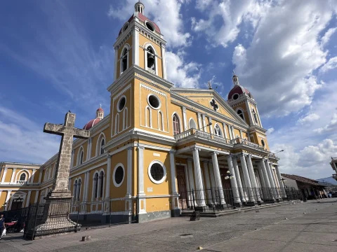 A low-angled photo of a yellow church building 