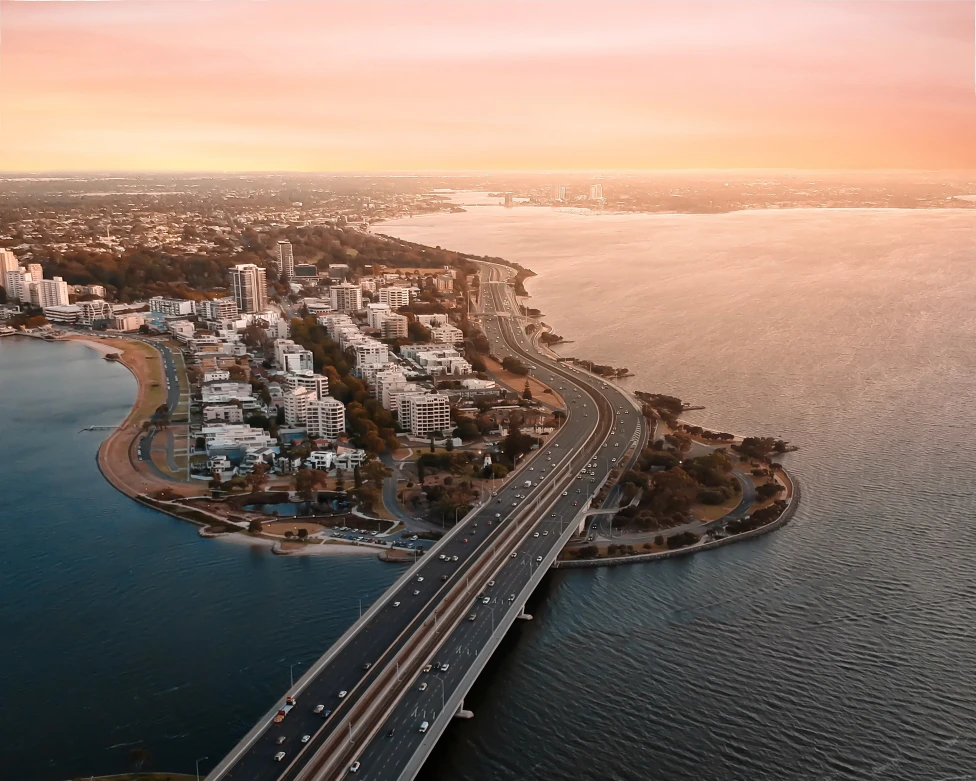 aerial view of bridge next to city during sunset