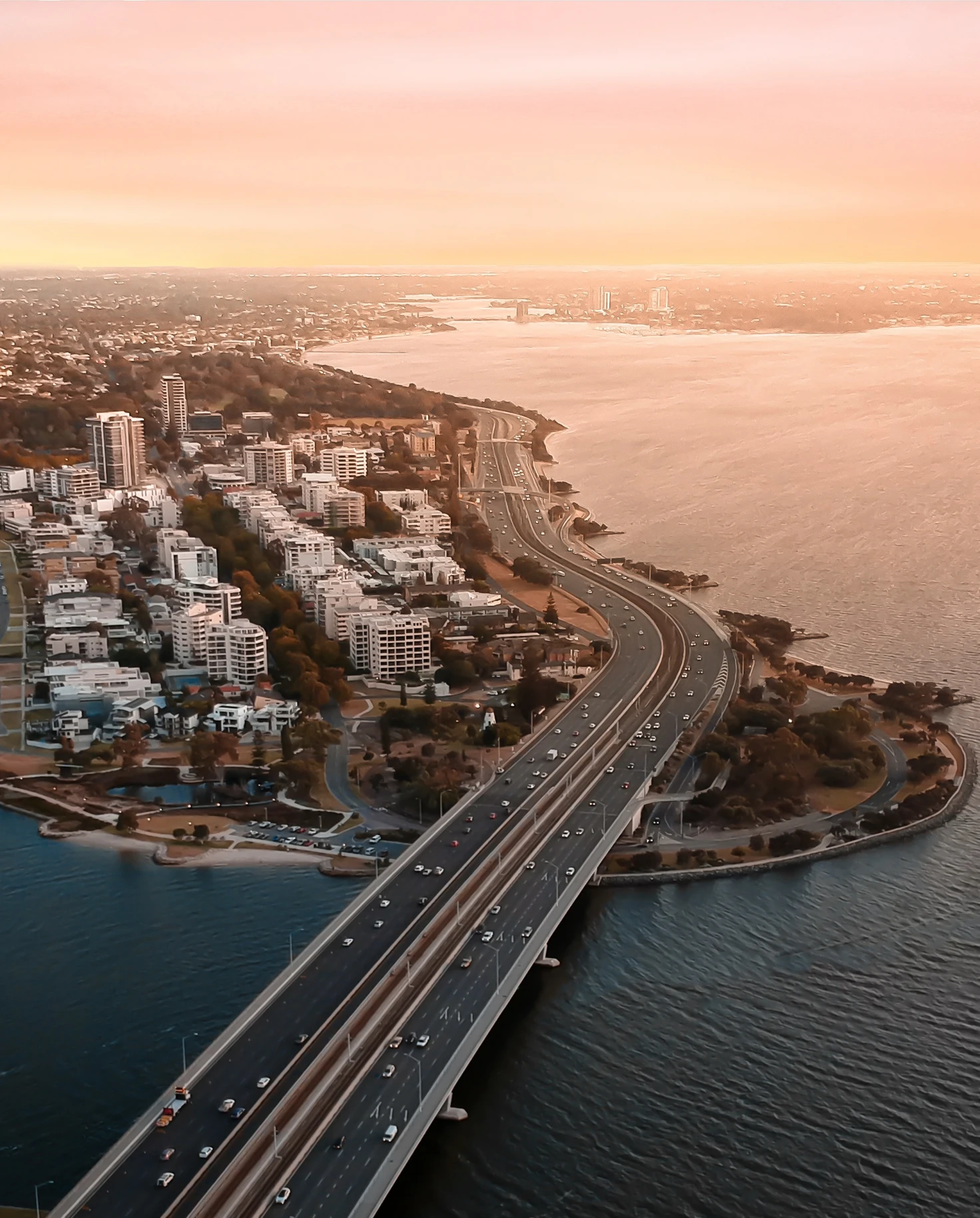 aerial view of bridge next to city during sunset