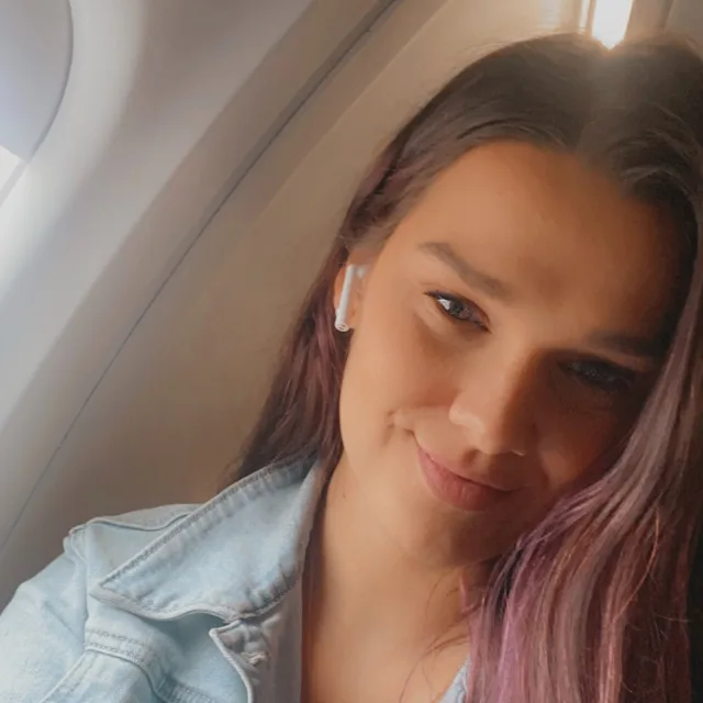 Travel Advisor Stephanie Dewane in a jean jacket on an airplane.
