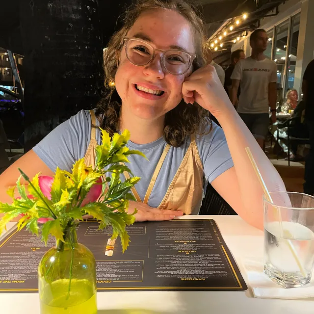 Travel advisor Agnes Dunne in glasses smiling at a dining table