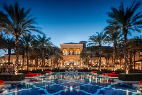 palatial hotel flanked by a large reflective pool at night