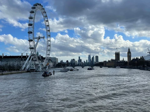 View of the London Eye on the water during a cloudy day