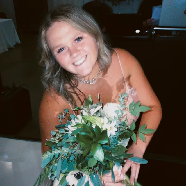 Julia Camello holding a bouquet and smiling 