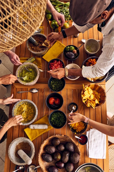 wooden table with bowls of guacamole and salsas