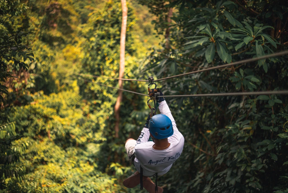 person hanging on a zipline during daytime