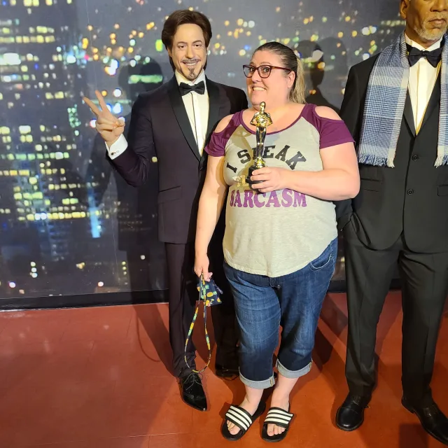 Travel Advisor Jodi Duncan at a wax museum posing with celebrities