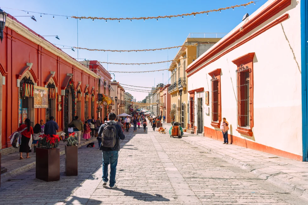 A colorful street with people walking in Oaxaca.