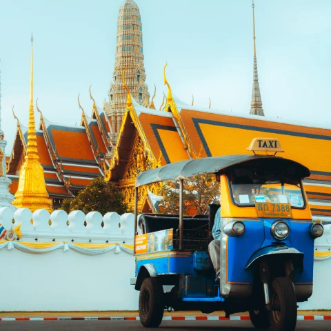 Thailand taxi tuk tuk next to a temple in Bangkok. 