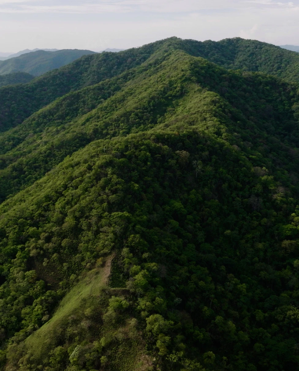 large green mountain with cloudy skies