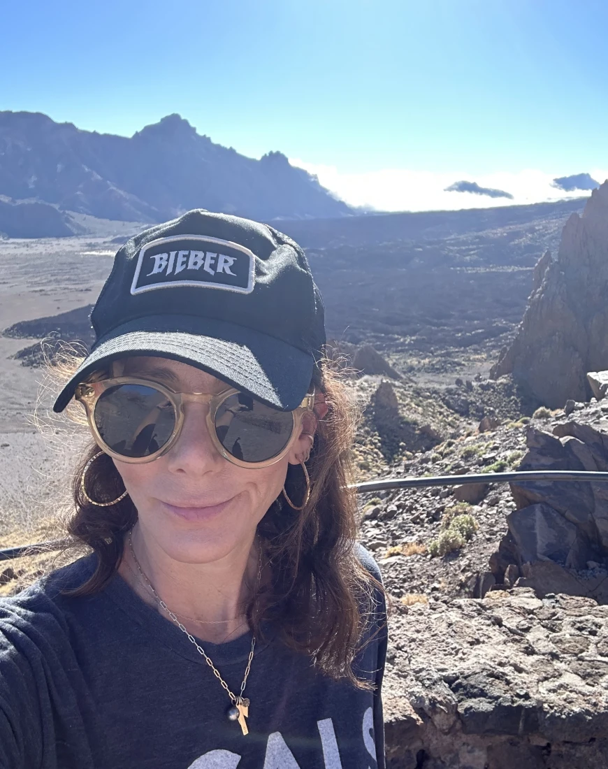 a woman in a hat and sunglasses in a sunny desert
