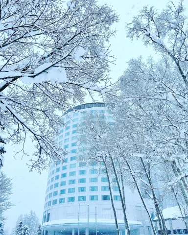 A view of the exterior of Hilton Niseko Village is snowy white landscape during winter.