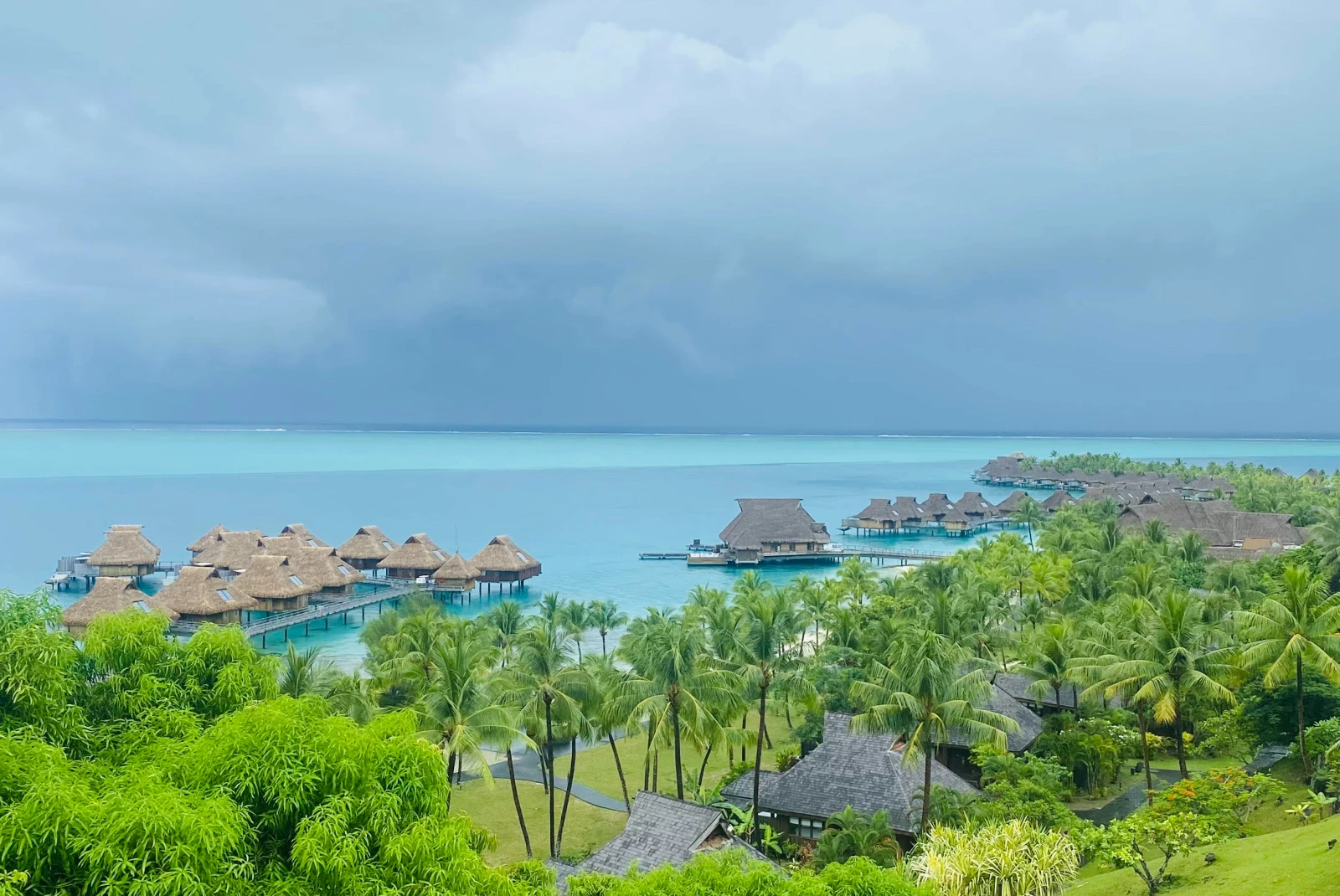 bungalows over water with cloudy skies