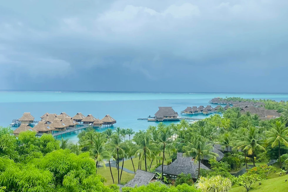 bungalows over water with cloudy skies