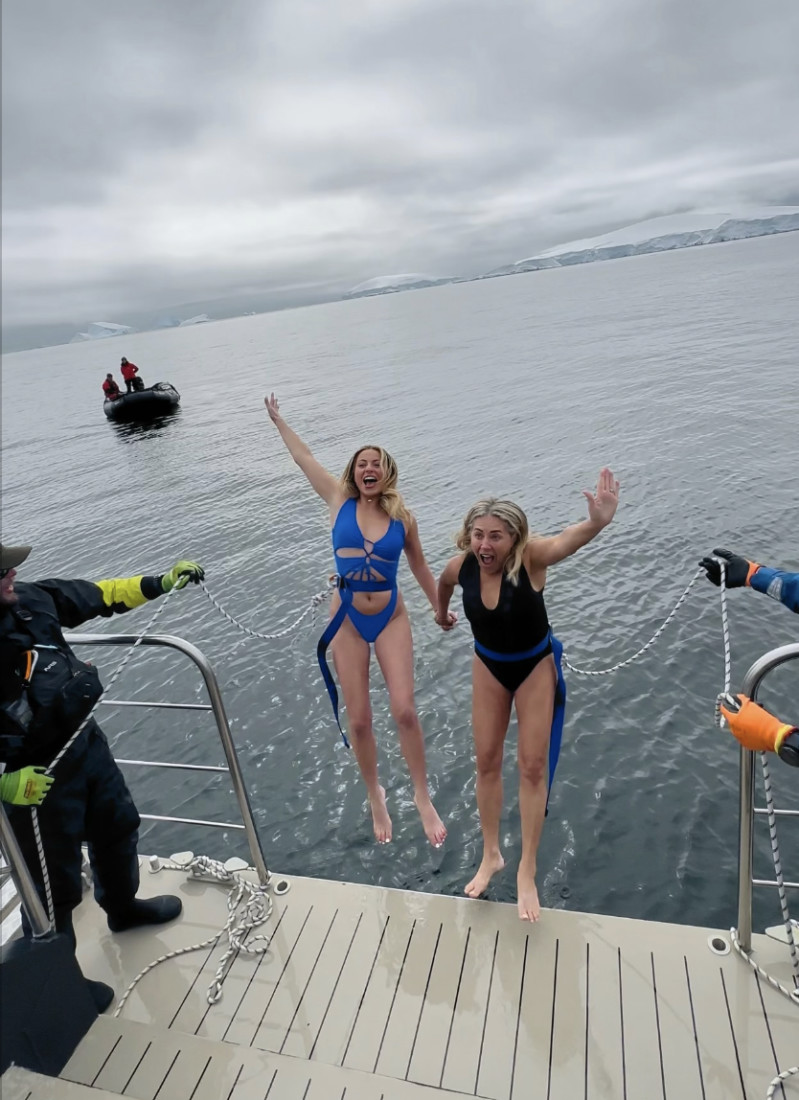 Two people in bathing suits jumping into the water