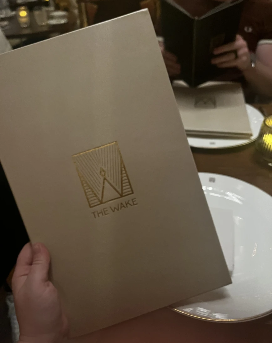 The food menu in off-white with a golden logo