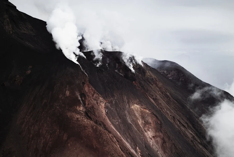A brown volcano with clouds