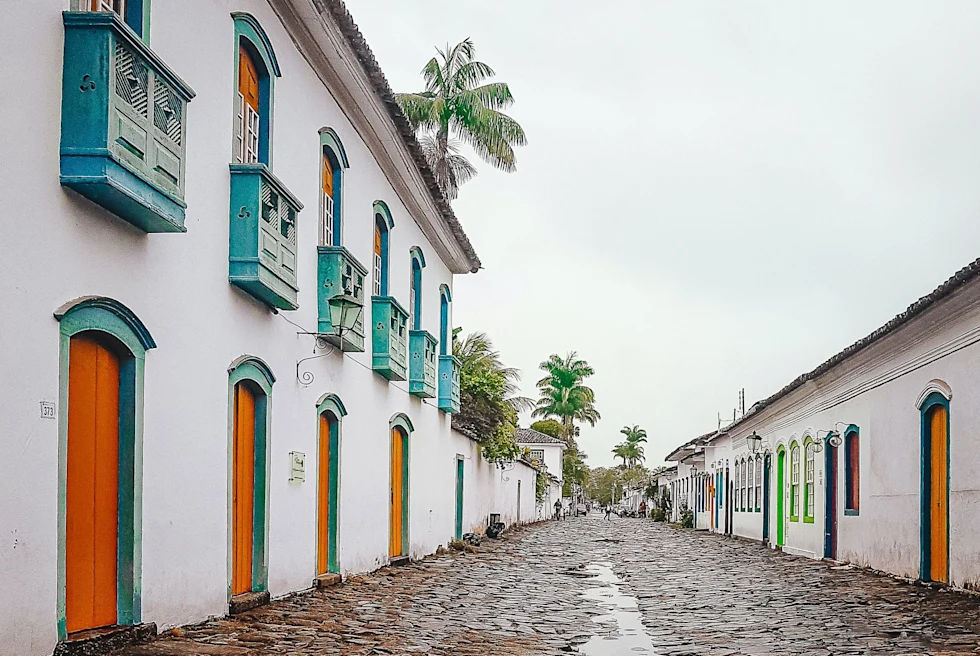 cobblestone street of white buildings with blue and orange doors