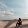 Fora travel agent Erin Brundage sitting on a sand dune
