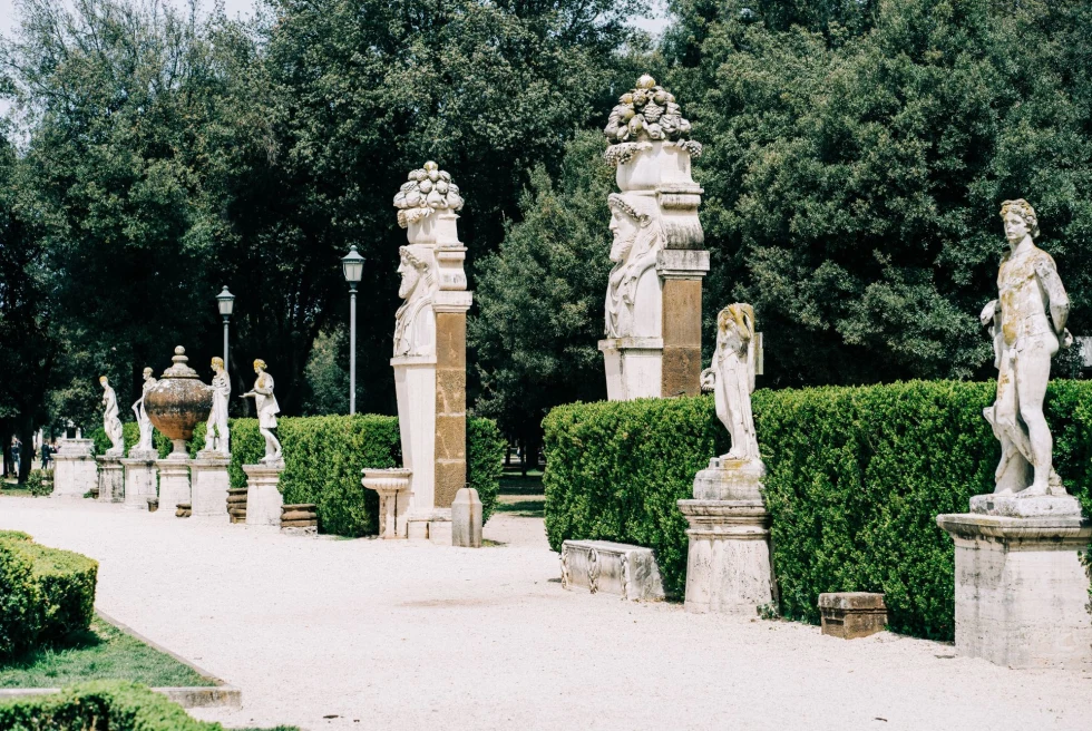 garden with ancient statues and manicured bushes