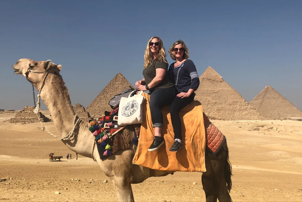 Enjoying the view of the pyramids by riding on a camel.