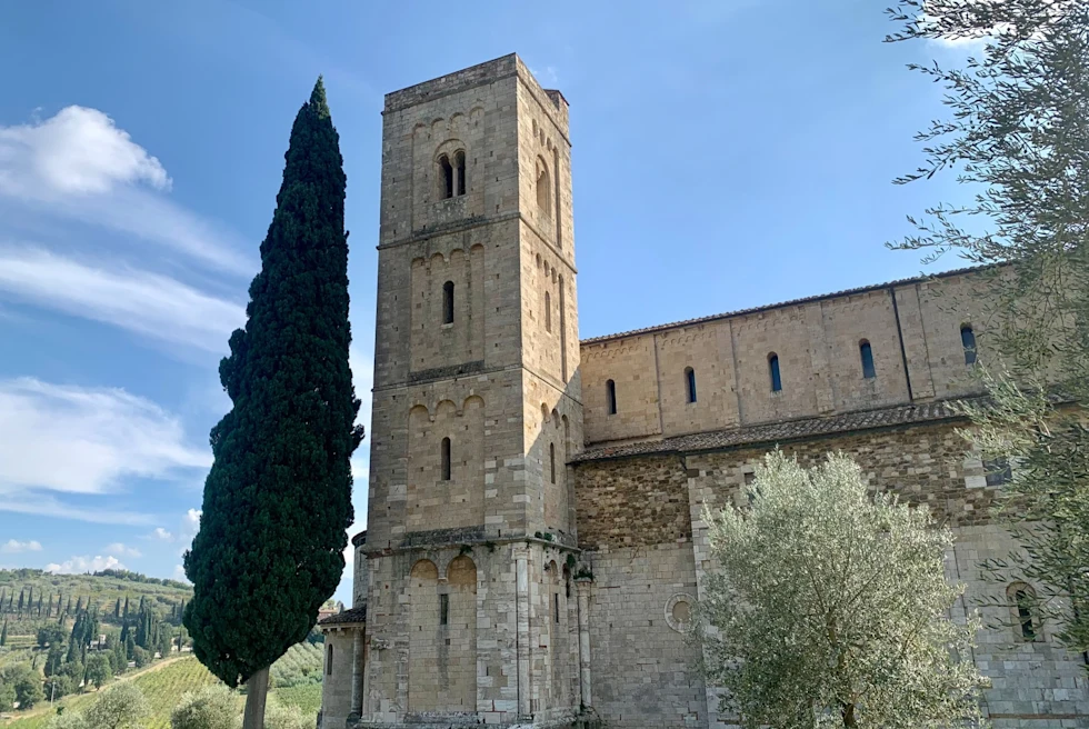 an old stone building with a tall tree