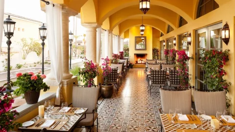 The patio restaurant at Omni Resort Scottsdale, with tables, a yellow ceiling and a checkered floor.