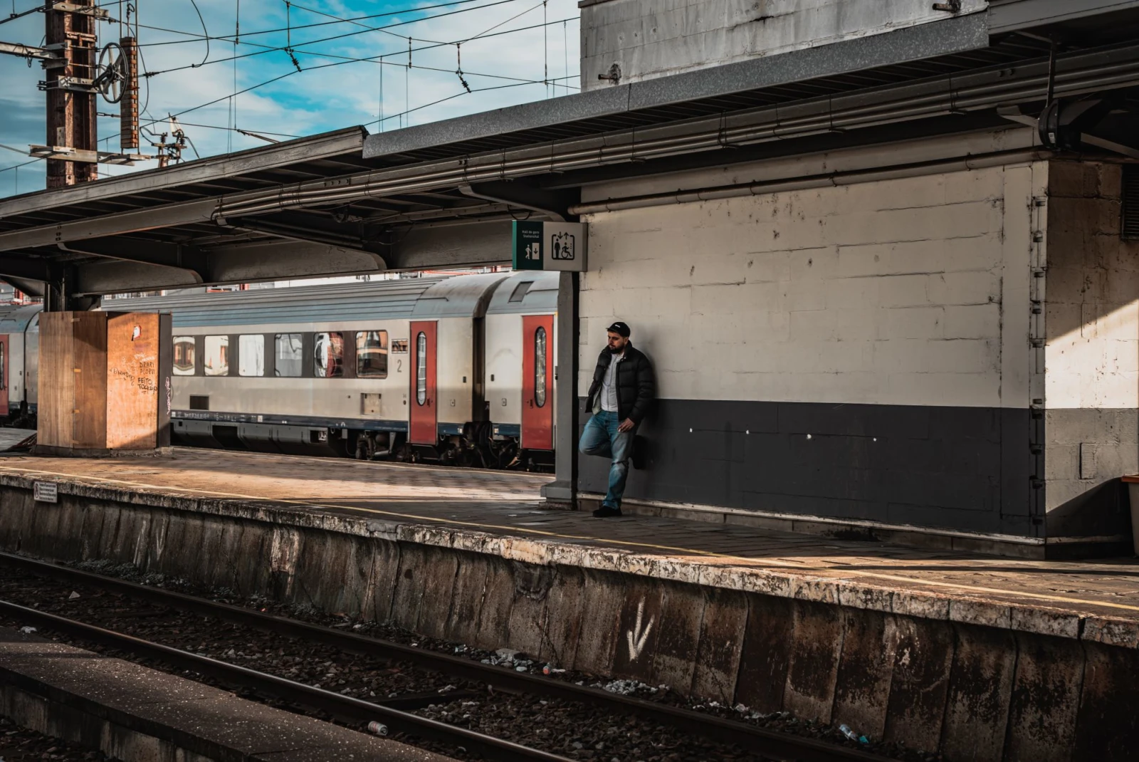 A man standing on a platform next to a train.