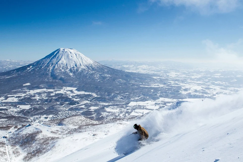 People hiking with skis on snow-covered mountain during daytime