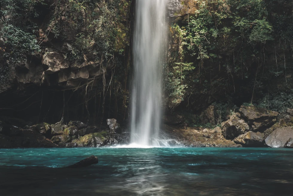A waterfall from a mountain into a lake.