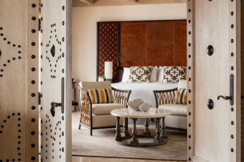 hotel room with a table and chairs in front of a large bed