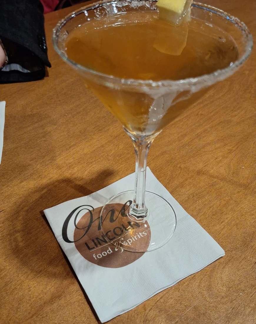 A cocktail in a martini glass sitting on a white napkin